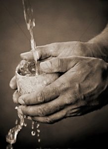 Water being poured into a wooden cup